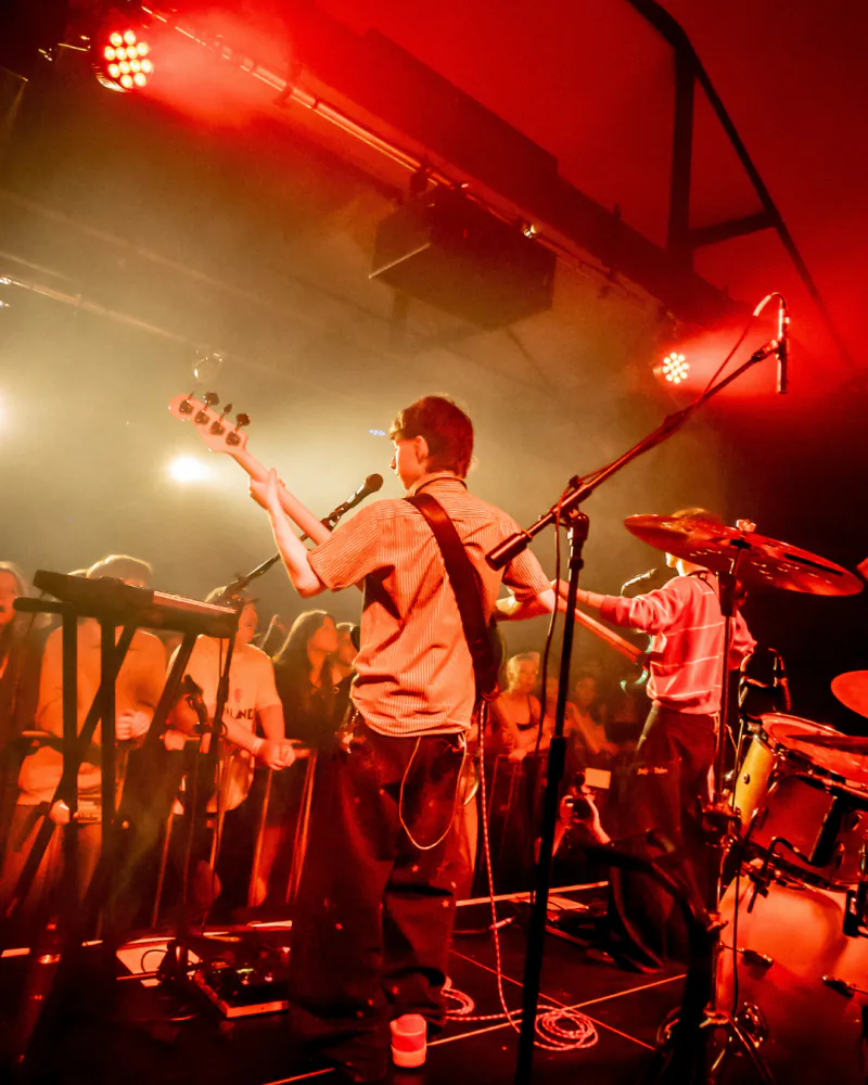 Band performing under red stage lights